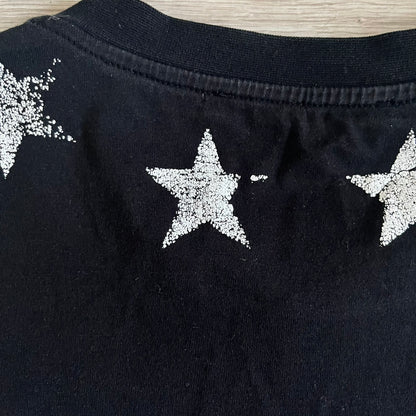 This Givenchy Distressed Black Stars Tee features the label’s iconic star motif from the FW18 season, with five stars across the front collar and four at the back. Crafted in Portugal from 100% cotton, it offers a slim fit and a soft, ribbed crewneck finish. A sought-after Givenchy stars shirt, and yes the distressed stars are intentional, not due to wear.