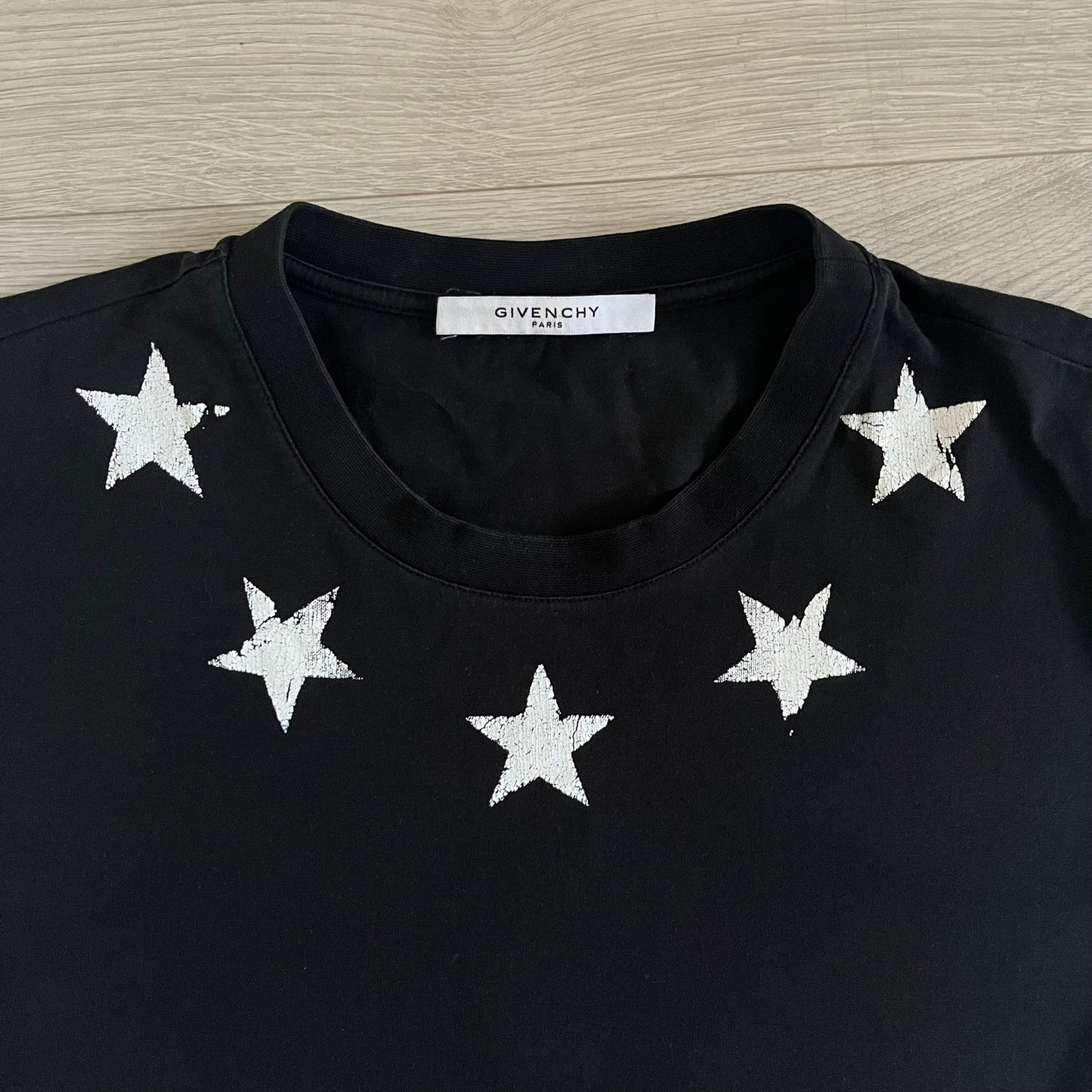 This Givenchy Distressed Black Stars Tee features the label’s iconic star motif from the FW18 season, with five stars across the front collar and four at the back. Crafted in Portugal from 100% cotton, it offers a slim fit and a soft, ribbed crewneck finish. A sought-after Givenchy stars shirt, and yes the distressed stars are intentional, not due to wear.