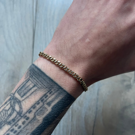 The Givenchy Gold-Tone Vintage Chain Bracelet features a thin gold-tone link chain with larger circular end links shaped like the Givenchy “G” connecting to the clasp. The foldover clasp is branded Givenchy Paris New York and is slightly oversized compared to the rest of the chain.