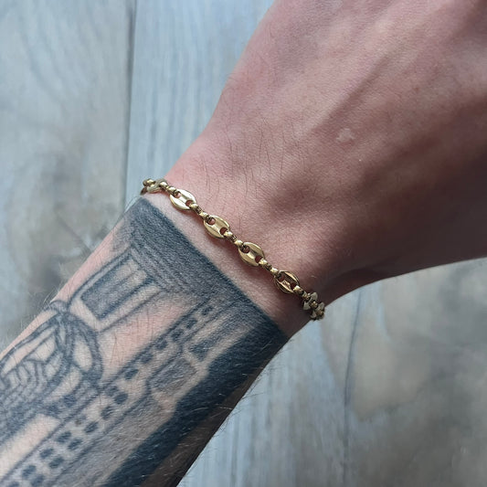 The Givenchy Gold-Tone Vintage Mariner Bracelet features a thin gold-tone mariner-style chain with larger circular end links connecting to the clasp. The foldover clasp is stamped Givenchy Paris New York and is oversized compared to the chain. Vintage piece with a consistent gold-tone finish.