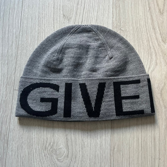 Gray Givenchy Jacquard beanie made from 100% wool and crafted in Italy. Features the black contrasting logo around the rolled brim, splitting “GIVE” and “NCHY” across the hem. Premium construction with a soft, comfortable fit.