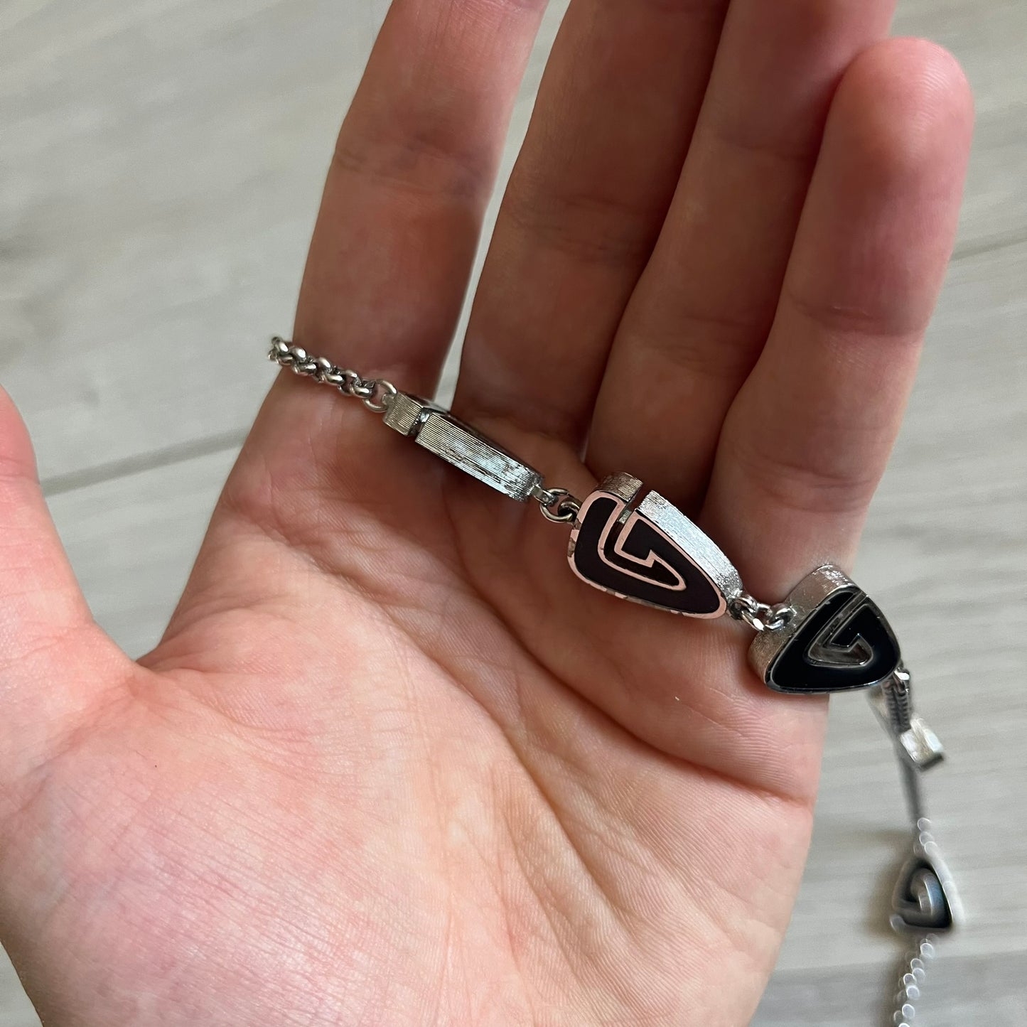 Givenchy Silver Enameled “G” Necklace from the late 1970s to early 1980s, crafted in silver with ten interlinked G-shaped triangular segments filled with black enamel. Signed Givenchy on the clasp. A rare collector’s jewelry item from Givenchy’s early archives.