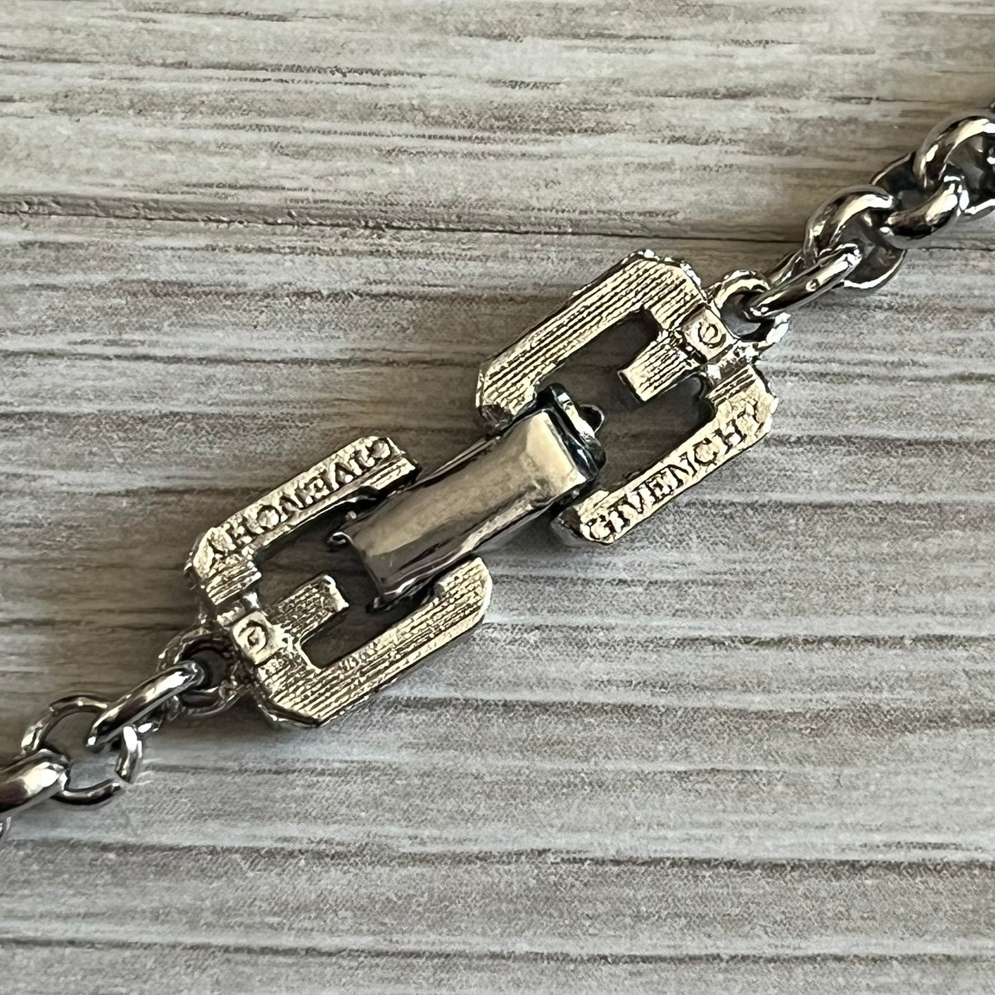 Givenchy Silver Enameled “G” Necklace from the late 1970s to early 1980s, crafted in silver with ten interlinked G-shaped triangular segments filled with black enamel. Signed Givenchy on the clasp. A rare collector’s jewelry item from Givenchy’s early archives.