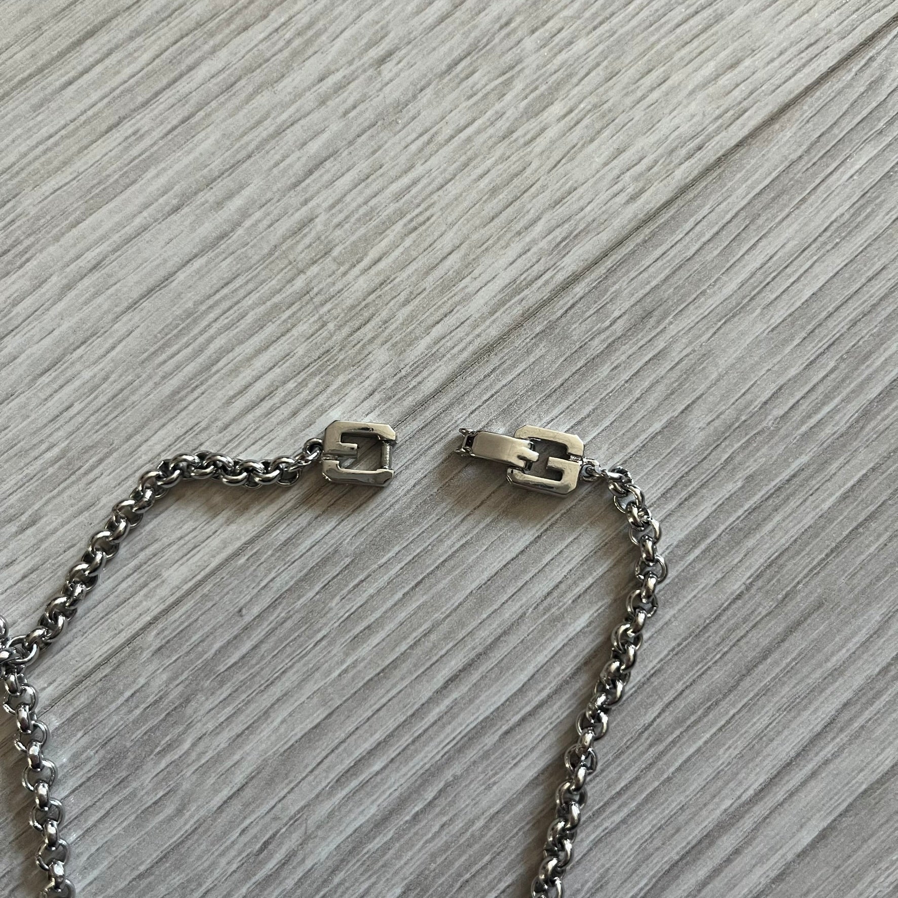 Givenchy Silver Enameled “G” Necklace from the late 1970s to early 1980s, crafted in silver with ten interlinked G-shaped triangular segments filled with black enamel. Signed Givenchy on the clasp. A rare collector’s jewelry item from Givenchy’s early archives.