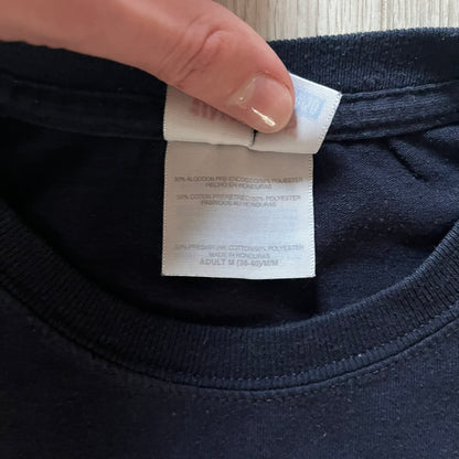 Navy Glock Perfection Tee from the 2000s, made on a Hanes Heavyweight 50/50 cotton-poly blend. Features a large white Glock Perfection logo on the back and a smaller matching logo on the left chest. Thick, high-quality construction.