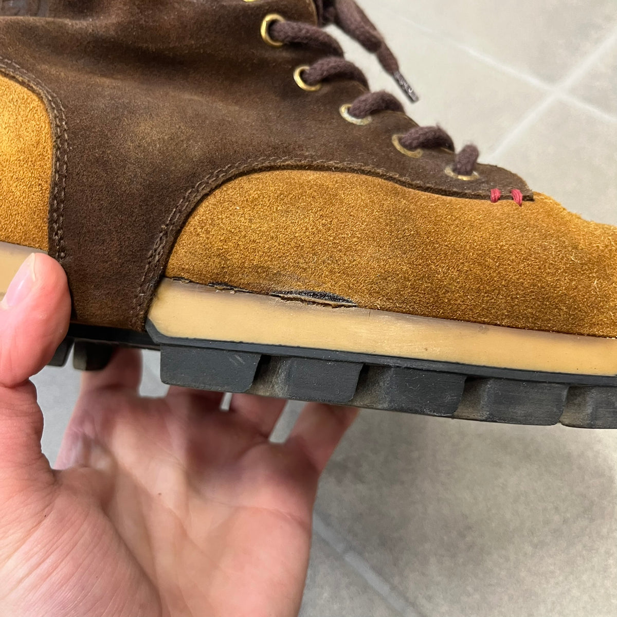 Gucci 2000’s Beige & Brown Shearling Lined Boots are made in Italy from beige and brown suede with a shearling-lined interior. A velcro strap with a Gucci logo closes the top, and the tongue has a leather tab with the Gucci logo. A green and red stripe runs around the top, a GG logo is on the side, and another GG logo appears on the sole along with a small one at the toe tip and a brown leather Gucci logo section on the sole. Due to age, the sole is falling apart and needs either gluing or a sole replacemen