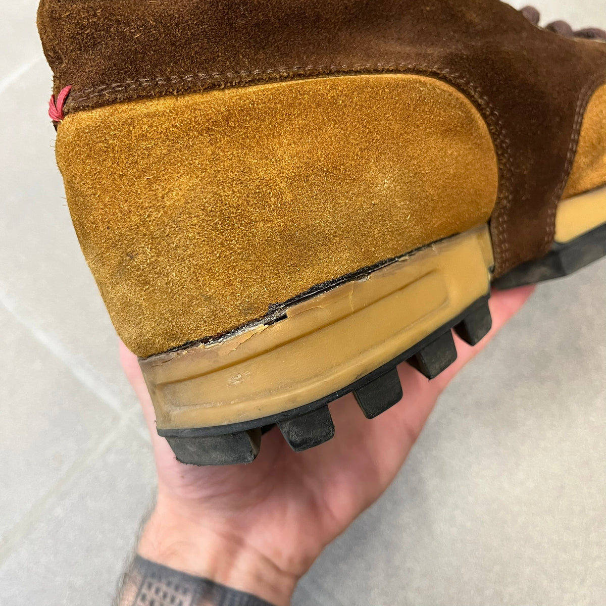 Gucci 2000’s Beige & Brown Shearling Lined Boots are made in Italy from beige and brown suede with a shearling-lined interior. A velcro strap with a Gucci logo closes the top, and the tongue has a leather tab with the Gucci logo. A green and red stripe runs around the top, a GG logo is on the side, and another GG logo appears on the sole along with a small one at the toe tip and a brown leather Gucci logo section on the sole. Due to age, the sole is falling apart and needs either gluing or a sole replacemen