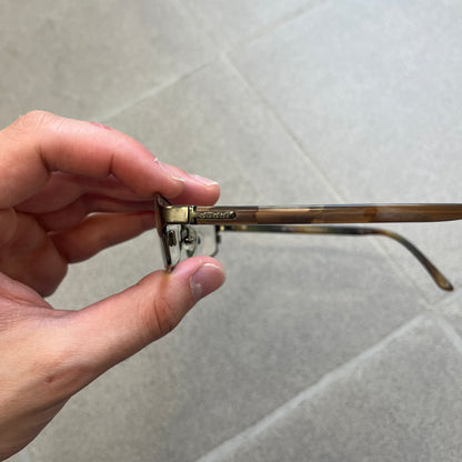 Gucci GG 1721 3U0 Brown Eyeglasses are a Made in Italy optical frame featuring a square full-rim design with a brown Havana-style colorway. The frames combine metal and plastic construction with a subtle Gucci logo detail on the front. Designed as a unisex model, they include prescription lenses and offer 100% UVA protection. Comes with an original black Gucci case.
