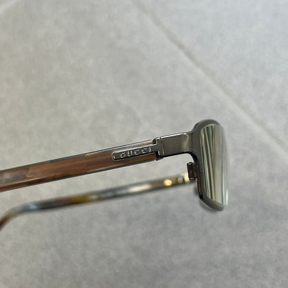 Gucci GG 1721 3U0 Brown Eyeglasses are a Made in Italy optical frame featuring a square full-rim design with a brown Havana-style colorway. The frames combine metal and plastic construction with a subtle Gucci logo detail on the front. Designed as a unisex model, they include prescription lenses and offer 100% UVA protection. Comes with an original black Gucci case.
