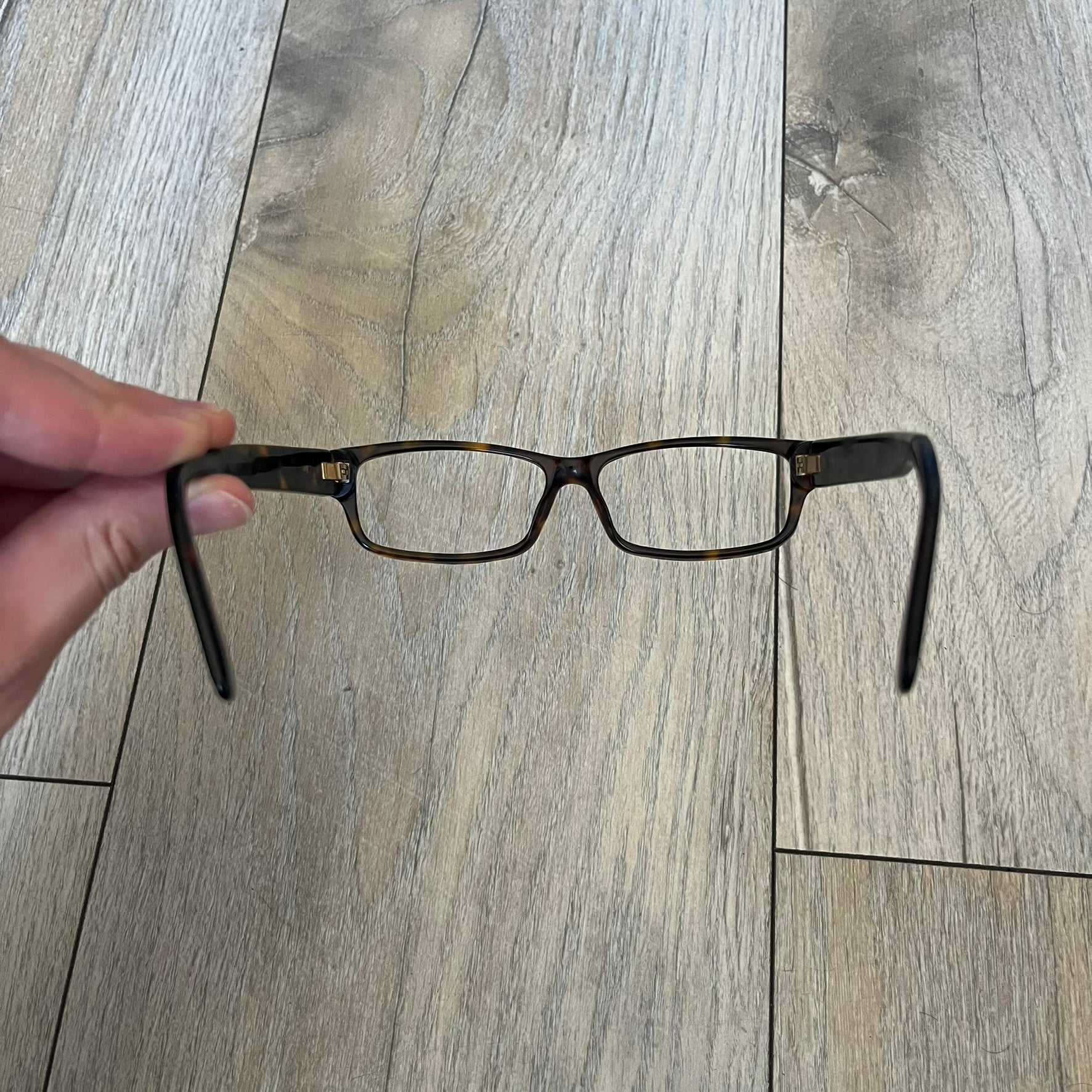 Gucci GG 3080 086 Glasses Frames are eyeglass frames made in Italy, featuring a brown and orange-toned acetate construction. The temples are detailed with silver GG monogram pattern accents and Gucci’s signature red and green web stripe near the front of the arms. The frames come with a matching monogram Gucci case.