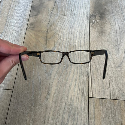 Gucci GG 3080 086 Glasses Frames are eyeglass frames made in Italy, featuring a brown and orange-toned acetate construction. The temples are detailed with silver GG monogram pattern accents and Gucci’s signature red and green web stripe near the front of the arms. The frames come with a matching monogram Gucci case.