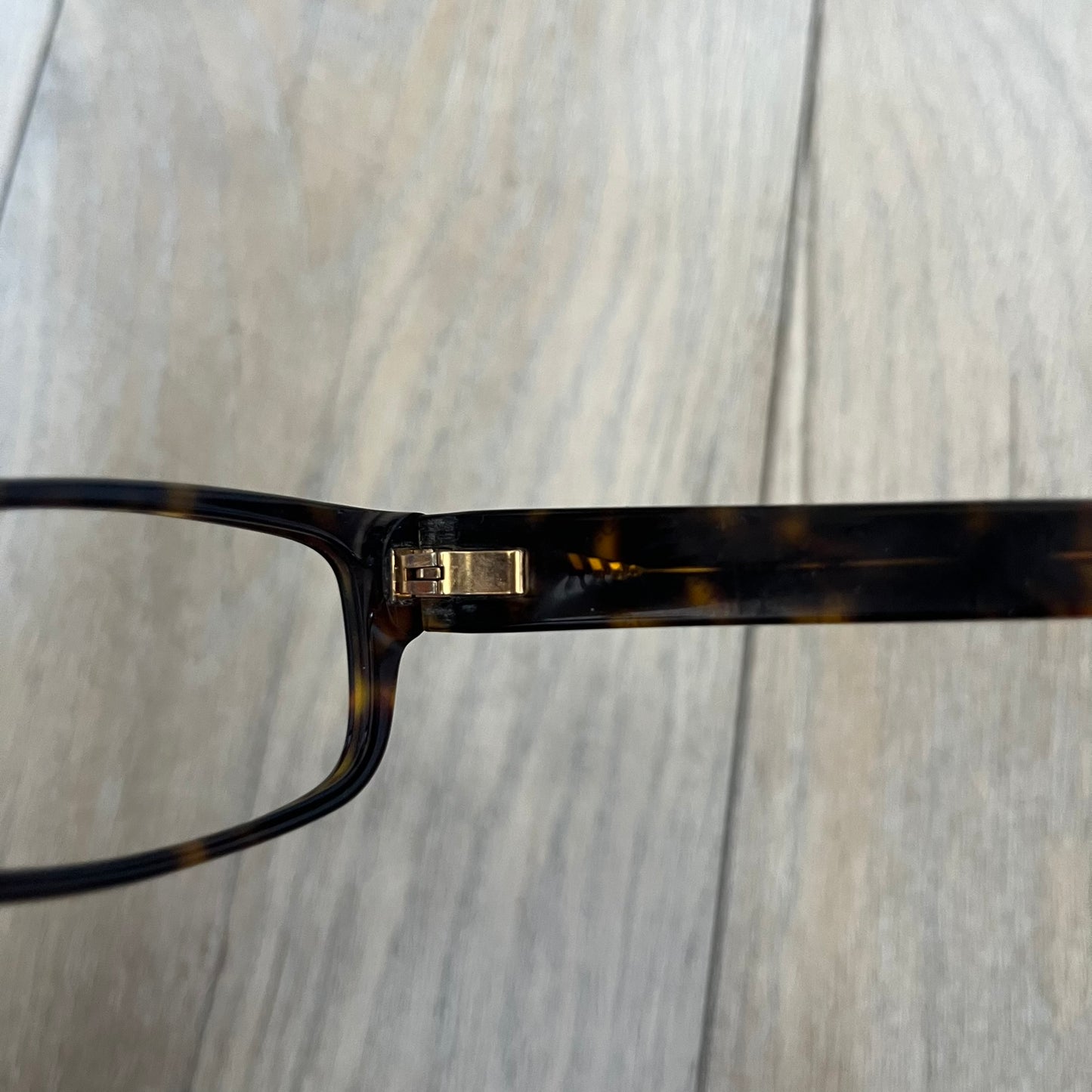 Gucci GG 3080 086 Glasses Frames are eyeglass frames made in Italy, featuring a brown and orange-toned acetate construction. The temples are detailed with silver GG monogram pattern accents and Gucci’s signature red and green web stripe near the front of the arms. The frames come with a matching monogram Gucci case.