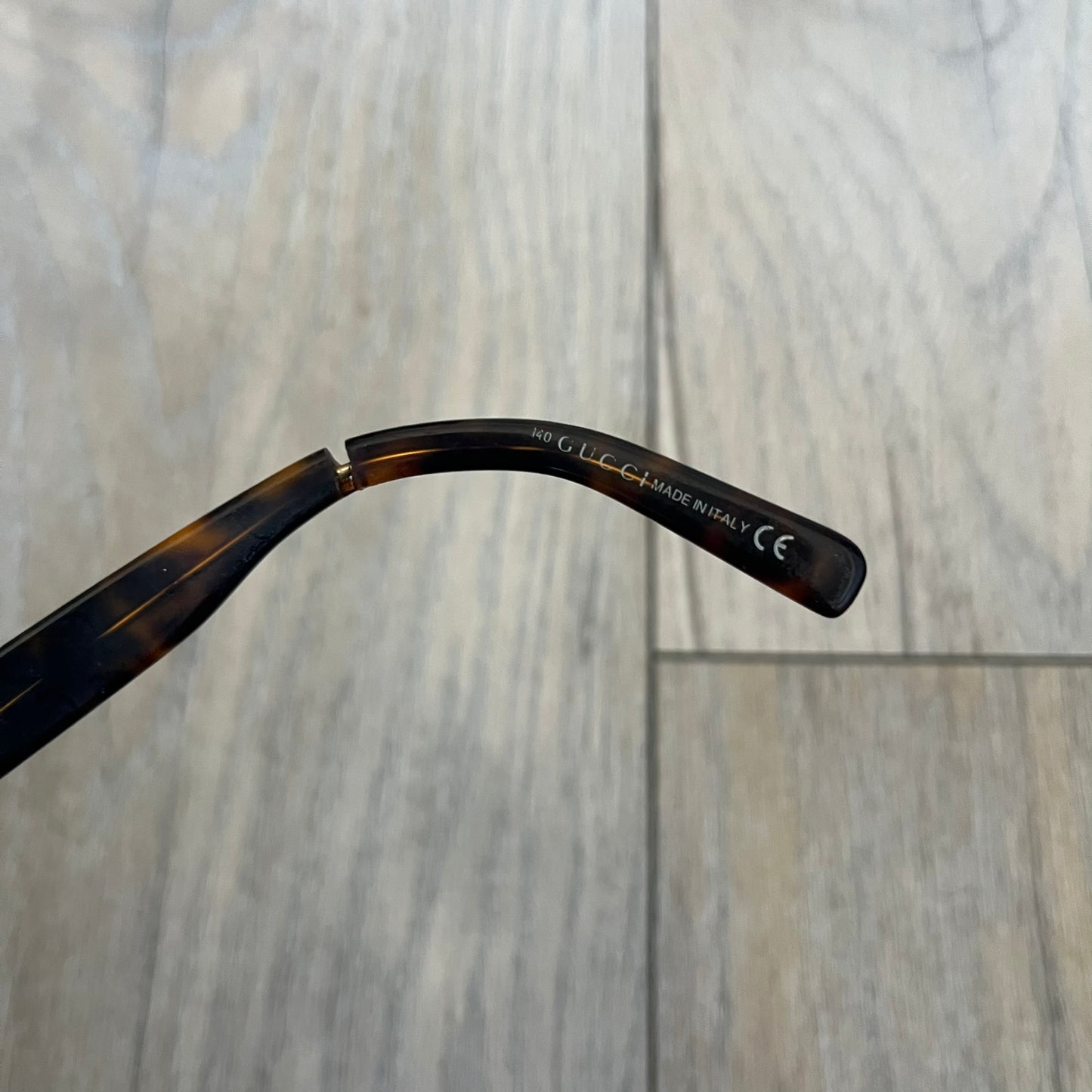 Gucci GG 3080 086 Glasses Frames are eyeglass frames made in Italy, featuring a brown and orange-toned acetate construction. The temples are detailed with silver GG monogram pattern accents and Gucci’s signature red and green web stripe near the front of the arms. The frames come with a matching monogram Gucci case.