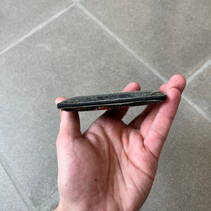 Gucci GG Supreme Kingsnake Card Holder features black and grey GG Supreme canvas with a red and black Kingsnake graphic and black leather trim. It has two card slots on the front, two on the back, and one central slot at the top.
