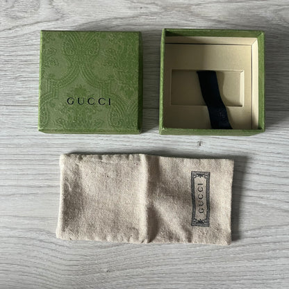Gucci wallet and box on a wooden surface