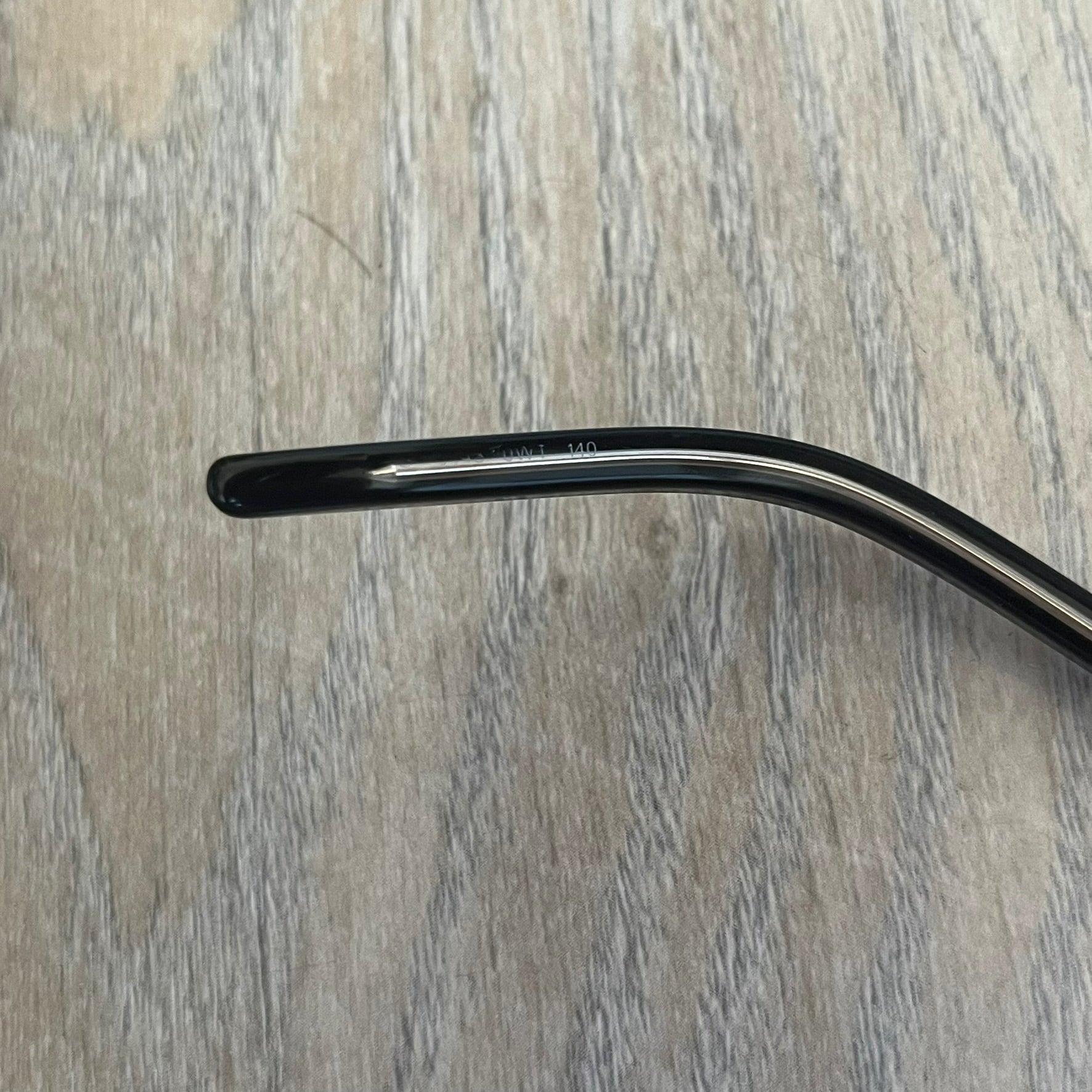 Gucci Gray-Blue Glasses Frames feature a translucent gray and dark blue acetate construction with a clear finish. Small silver GG logos are positioned on the front sides of the frames near the hinges. The frames are sold without lenses and come with a Gucci monogram case and a brown cleaning cloth.
