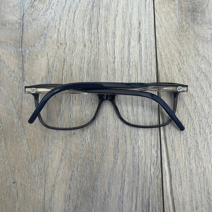 Gucci Gray-Blue Glasses Frames feature a translucent gray and dark blue acetate construction with a clear finish. Small silver GG logos are positioned on the front sides of the frames near the hinges. The frames are sold without lenses and come with a Gucci monogram case and a brown cleaning cloth.