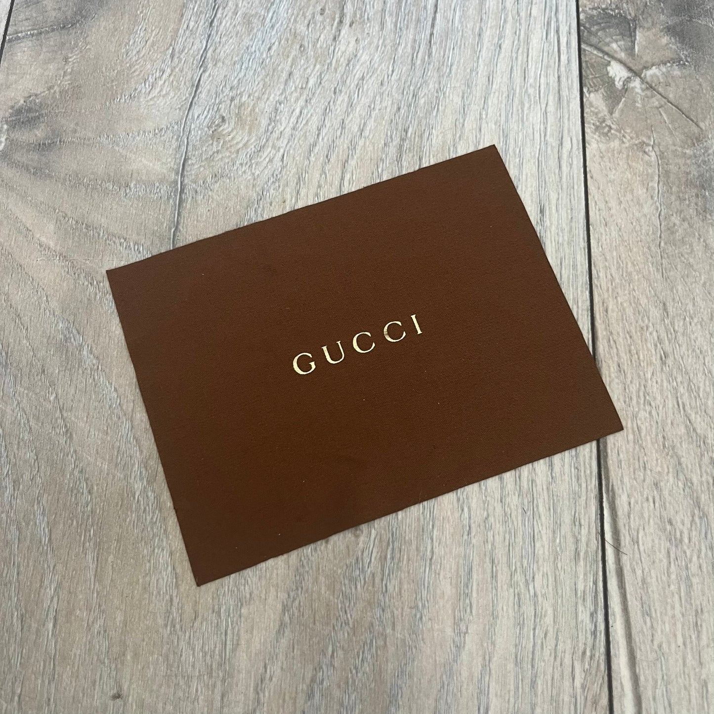 Gucci Gray-Blue Glasses Frames feature a translucent gray and dark blue acetate construction with a clear finish. Small silver GG logos are positioned on the front sides of the frames near the hinges. The frames are sold without lenses and come with a Gucci monogram case and a brown cleaning cloth.
