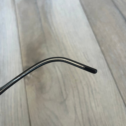 Gucci Gray-Blue Glasses Frames feature a translucent gray and dark blue acetate construction with a clear finish. Small silver GG logos are positioned on the front sides of the frames near the hinges. The frames are sold without lenses and come with a Gucci monogram case and a brown cleaning cloth.