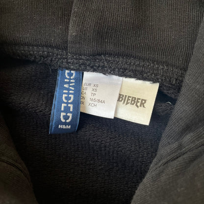 H&amp;M 2016 Justin Bieber Purpose World Tour Black Hoodie is from the 2016 H&amp;M Divided collaboration collection, featuring a white "Purpose" logo with "World Tour" text below it on the front. Both sleeves display big red "WORLD TOUR" text.