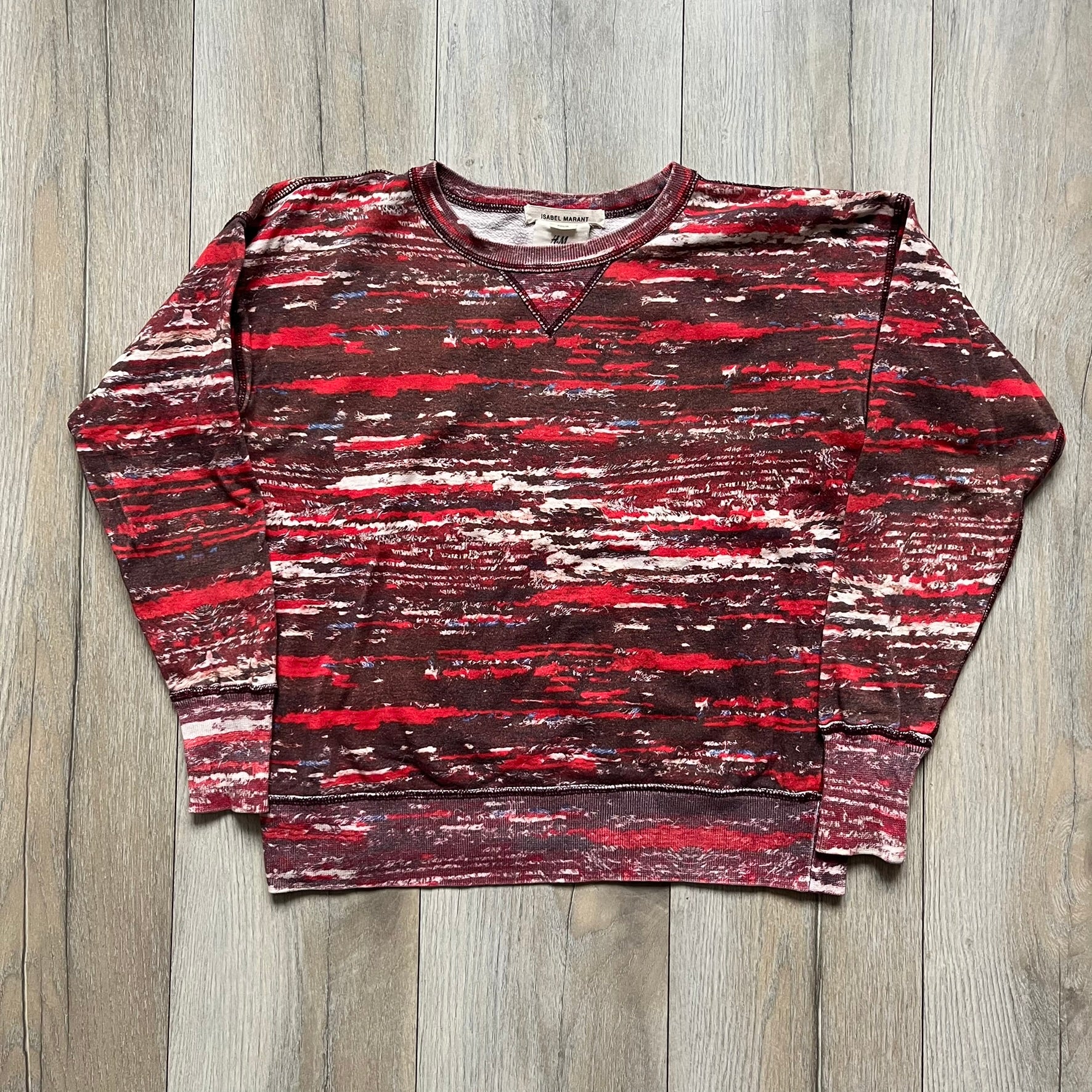 H&M x Isabel Marant 2013 Red Disorder Sweater is a women’s knit sweater in red, made from a soft fabric blend. The sweater features a deliberately distressed knit throughout, with ribbed cuffs and hem for structure. It was released as part of the H&M x Isabel Marant 2013 collaboration.