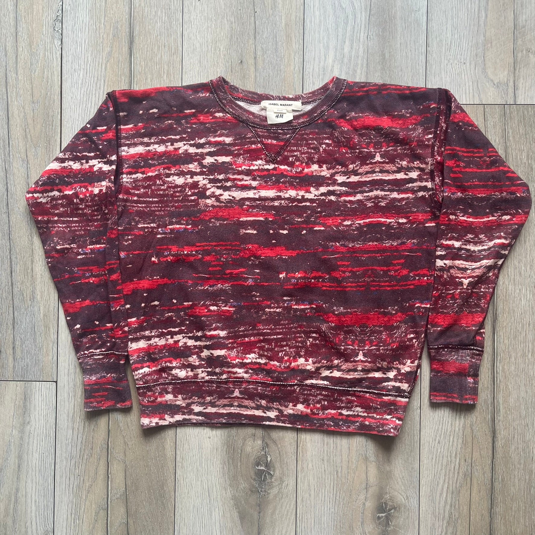 H&amp;M x Isabel Marant 2013 Red Disorder Sweater is a women’s knit sweater in red, made from a soft fabric blend. The sweater features a deliberately distressed knit throughout, with ribbed cuffs and hem for structure. It was released as part of the H&amp;M x Isabel Marant 2013 collaboration