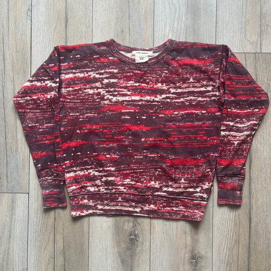 H&amp;M x Isabel Marant 2013 Red Disorder Sweater is a women’s knit sweater in red, made from a soft fabric blend. The sweater features a deliberately distressed knit throughout, with ribbed cuffs and hem for structure. It was released as part of the H&amp;M x Isabel Marant 2013 collaboration