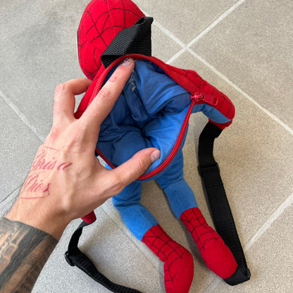 H&M x Marvel 2006 Spider-Man Backpack is a red and blue backpack shaped like Spider-Man in his signature costume. The design features embroidered eye details and an embroidered spider logo on the chest. It has a compact back pocket and straps connected from the character’s hands to the legs. Includes 2006 H&M x Marvel licensing details.
