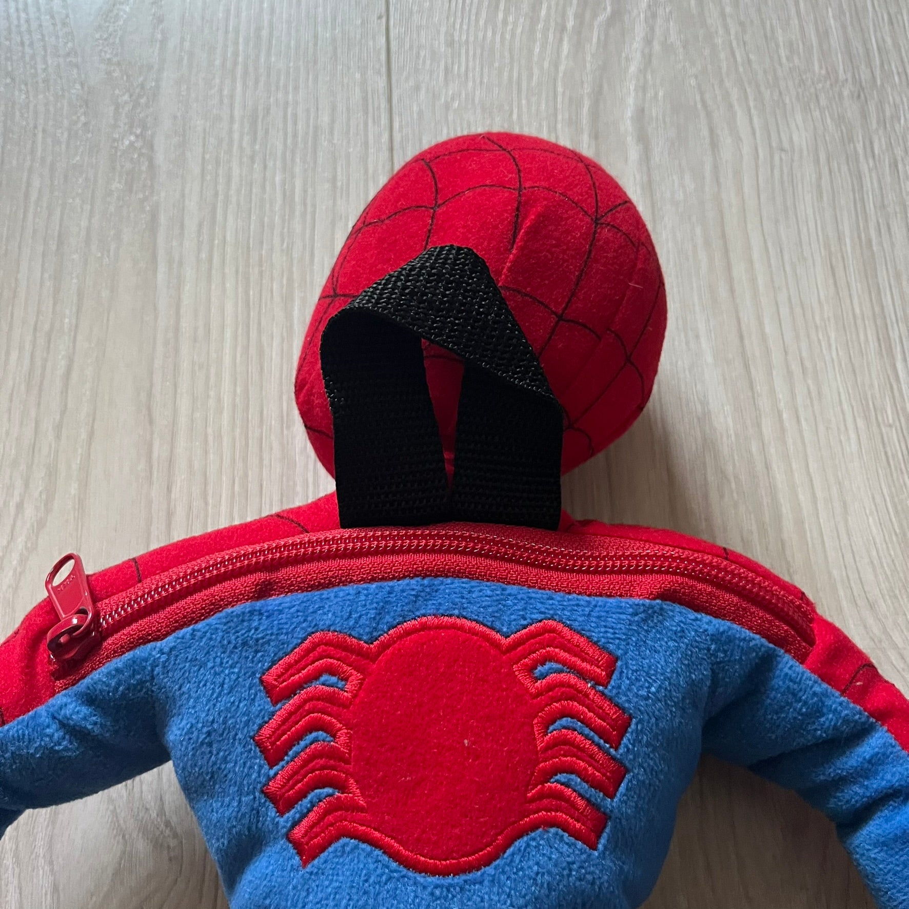 2006 H&M x Marvel Spider-Man Backpack shaped as Spider-Man in his signature red and blue outfit. Features a compact back pocket and unique strap placement connecting his hands to his legs. Rare early 2000s collaboration collectible.