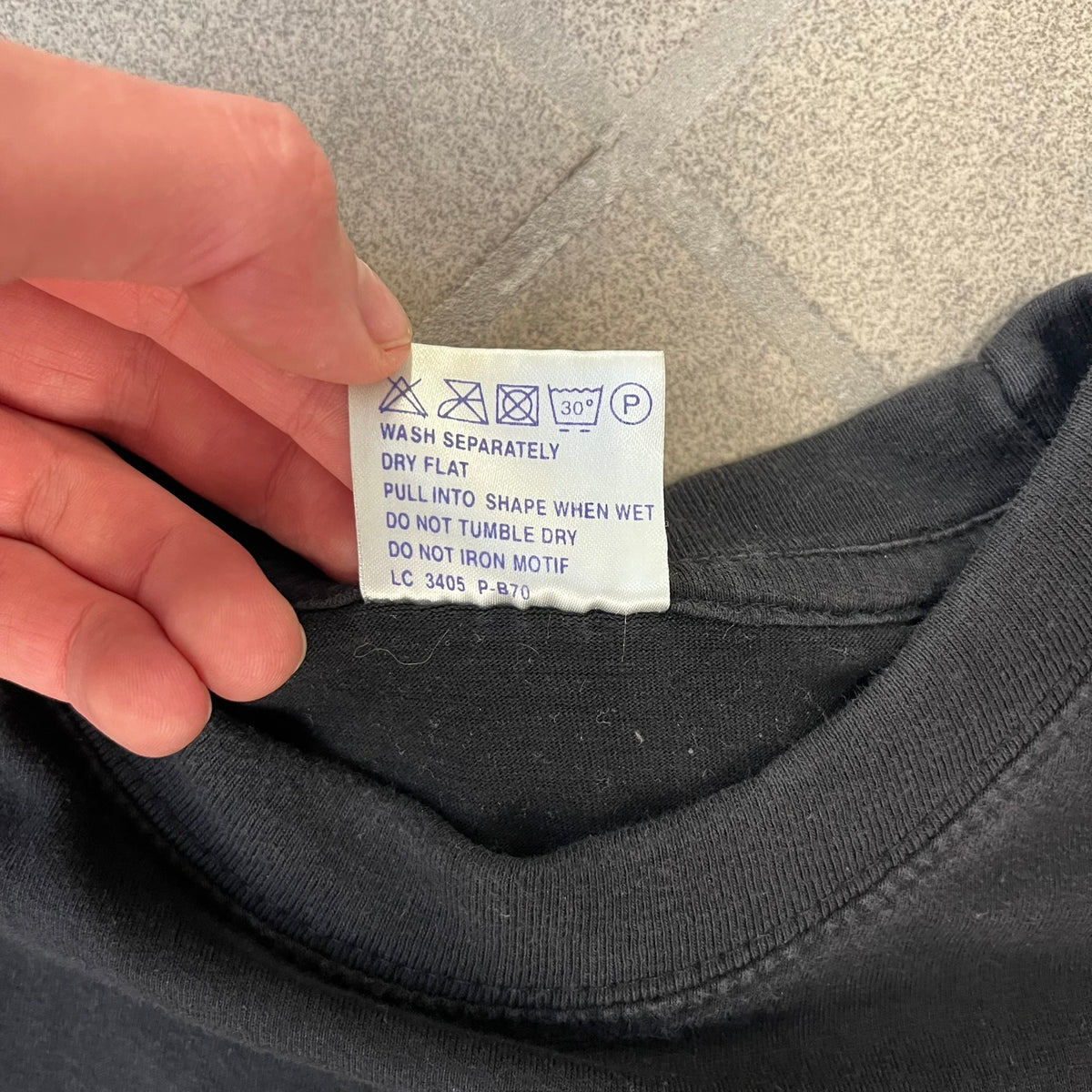 Half-Life 2 2000’s Lambda Black Tee is a black, 100% cotton T-shirt with a white Half-Life 2 logo on the front, showing the lambda symbol inside a circle with a “2” in the corner and a small TM mark beside it.