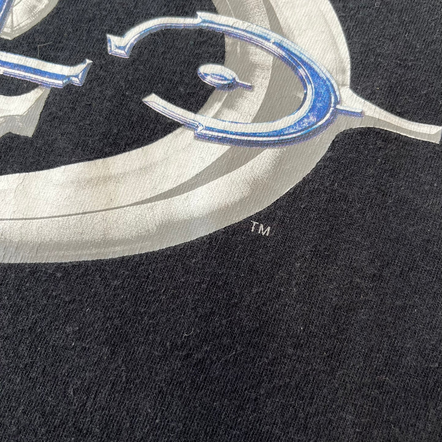 Halo 2 Xbox 2004 Black Tee is a black promotional T-shirt featuring a large white and blue Halo 2 graphic on the front. The upper back has a green original Xbox logo positioned below the collar.