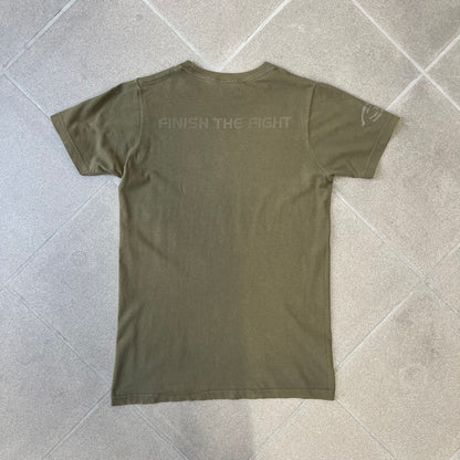 Halo 3 Finish the Fight 2006 Tee is a khaki, 100% cotton T-shirt with a green Master Chief graphic on the front against a lighter background. A Halo 3 logo is on one sleeve, and “Finish the Fight” text runs across the upper back. The neck tag is licensed for Xbox 360 and carries 2005 licensing on the other side.