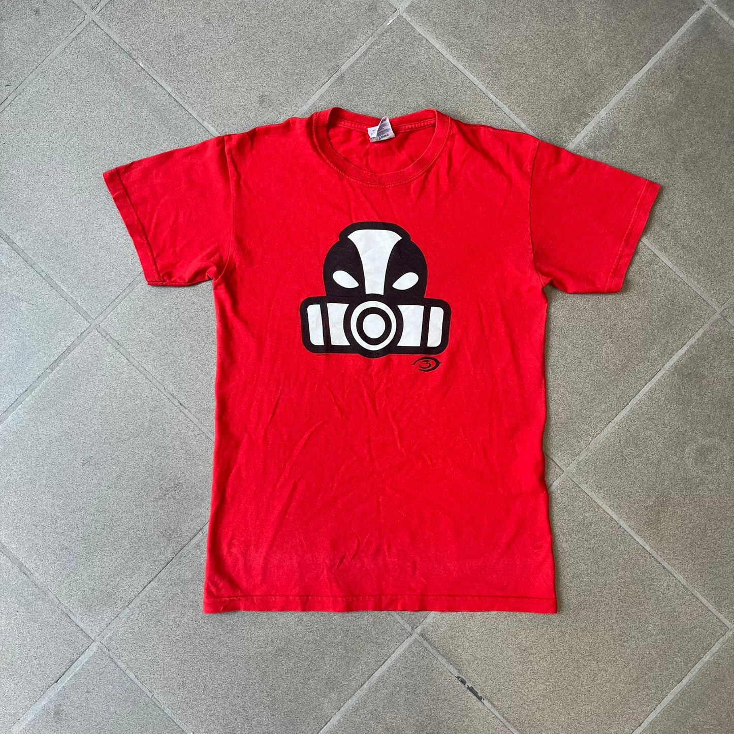Halo 3 Grunt Emblem 2007 Red Tee features a red T-shirt made on a Gildan blank. The front has a large white and black Grunt emblem graphic, with a small Halo 3 logo below it on the right and Microsoft 2007 licensing text below it on the left. Made from 100% cotton.
