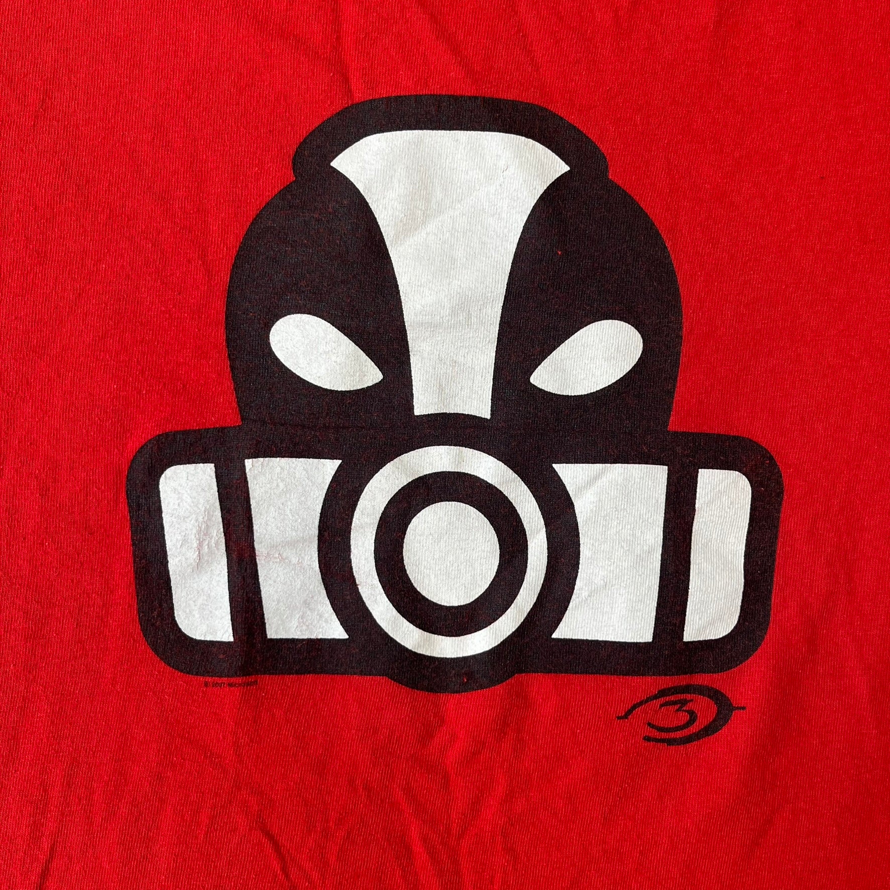 Halo 3 Grunt Emblem 2007 Red Tee features a red T-shirt made on a Gildan blank. The front has a large white and black Grunt emblem graphic, with a small Halo 3 logo below it on the right and Microsoft 2007 licensing text below it on the left. Made from 100% cotton.
