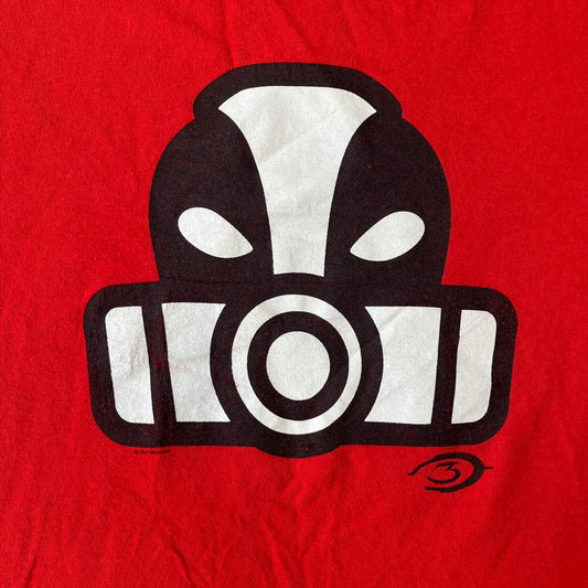 Halo 3 Grunt Emblem 2007 Red Tee features a red T-shirt made on a Gildan blank. The front has a large white and black Grunt emblem graphic, with a small Halo 3 logo below it on the right and Microsoft 2007 licensing text below it on the left. Made from 100% cotton.
