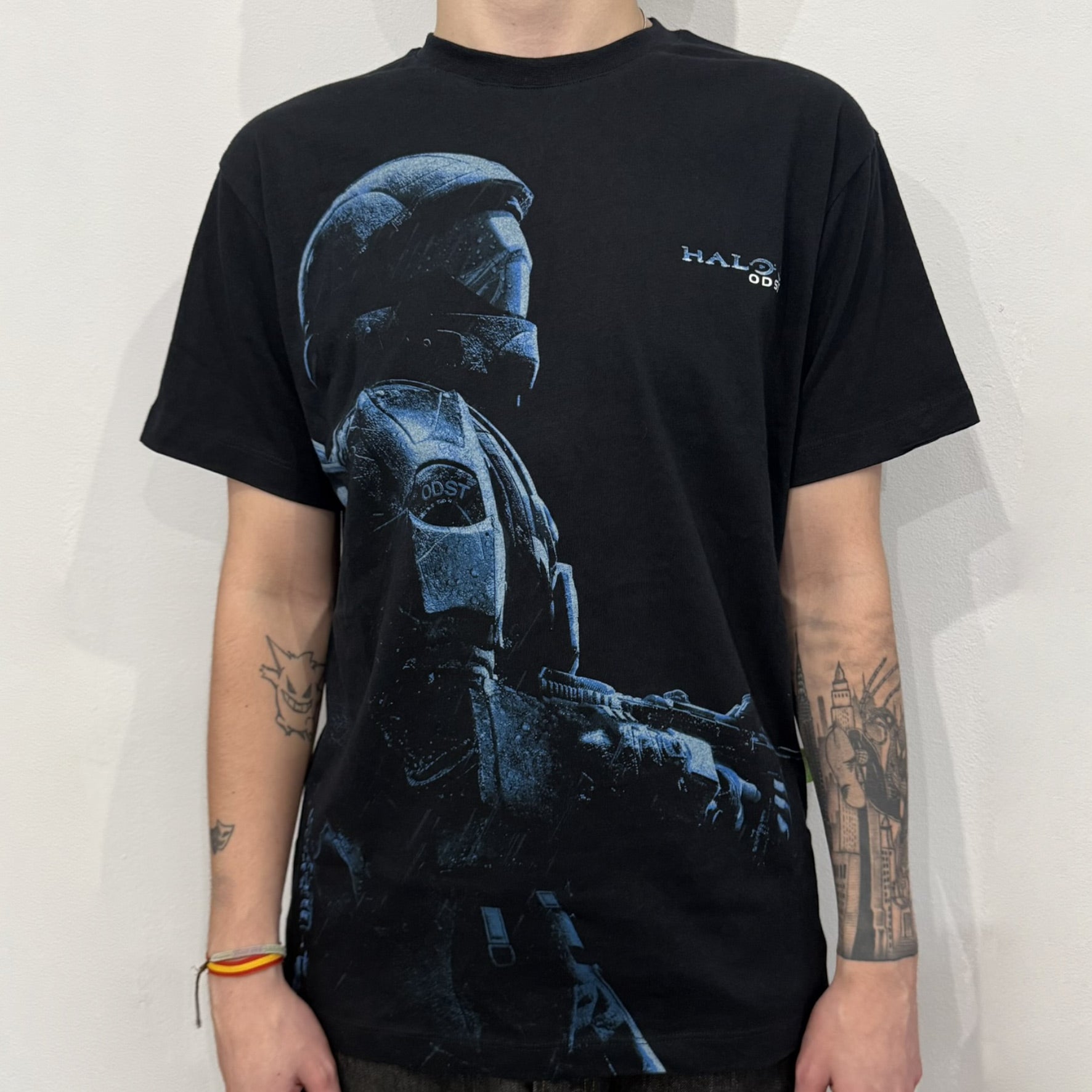 Black Halo 3: ODST Tee for Xbox 360 featuring a large blue Master Chief graphic on the front right and a small logo on the left chest. Made from high-quality cotton with Xbox 360 tags on the collar and a green one on the side. A super rare collectible for Halo fans.