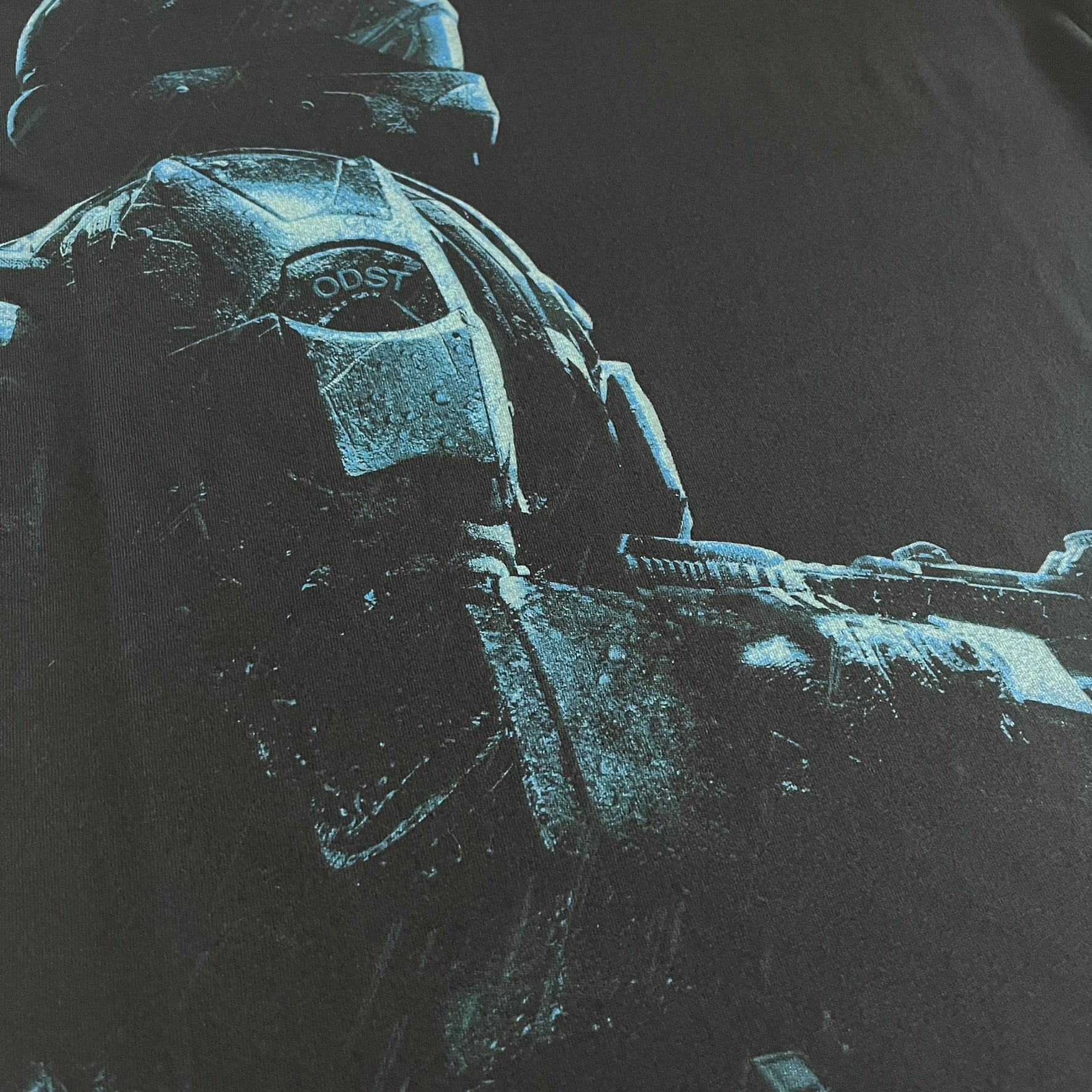 Black Halo 3: ODST Tee for Xbox 360 featuring a large blue Master Chief graphic on the front right and a small logo on the left chest. Made from high-quality cotton with Xbox 360 tags on the collar and a green one on the side. A super rare collectible for Halo fans.