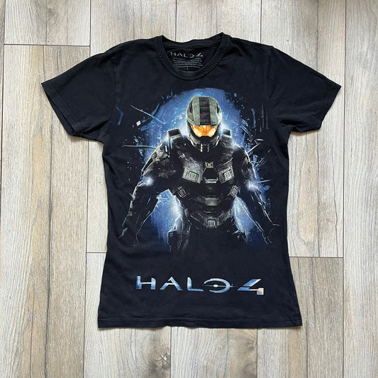 Halo 4 Master Chief 2012 Tee is a black graphic T-shirt featuring a large front print of Master Chief standing in front of a blue sci-fi style background. The design includes a detailed illustration of the character with a large Halo 4 logo printed below the graphic. The shirt has a 2012 Microsoft licensed neck tag.