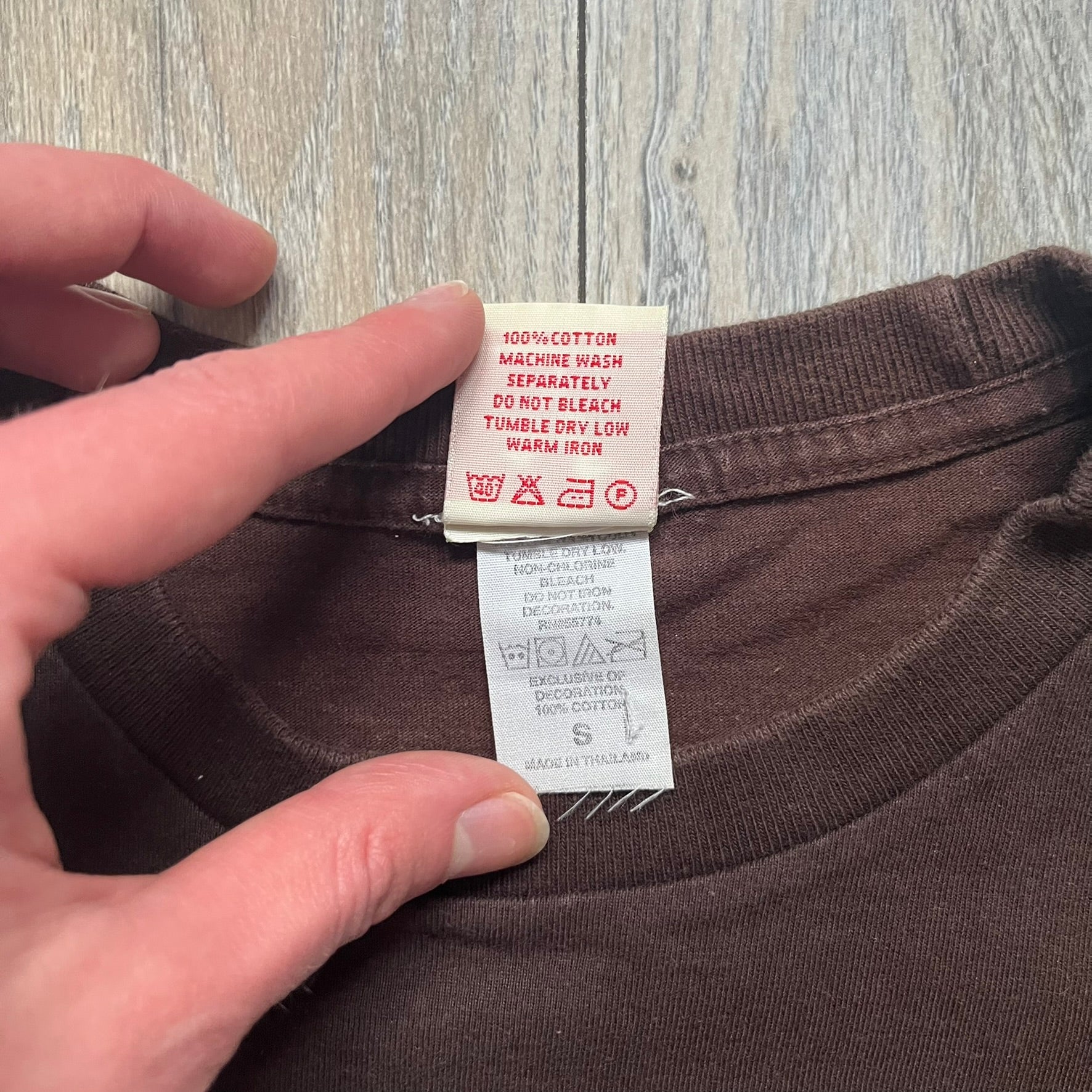 Happy Tree Friends Lumpy Fan Brown Tee from 2005 is a brown T-shirt featuring Lumpy on the front holding and licking a fan. On the back, the same Lumpy graphic appears without the tongue, with visible blood on the fan and face. A small Happy Tree Friends logo is printed in the lower front corner, and the neck tag features a red heart detail.