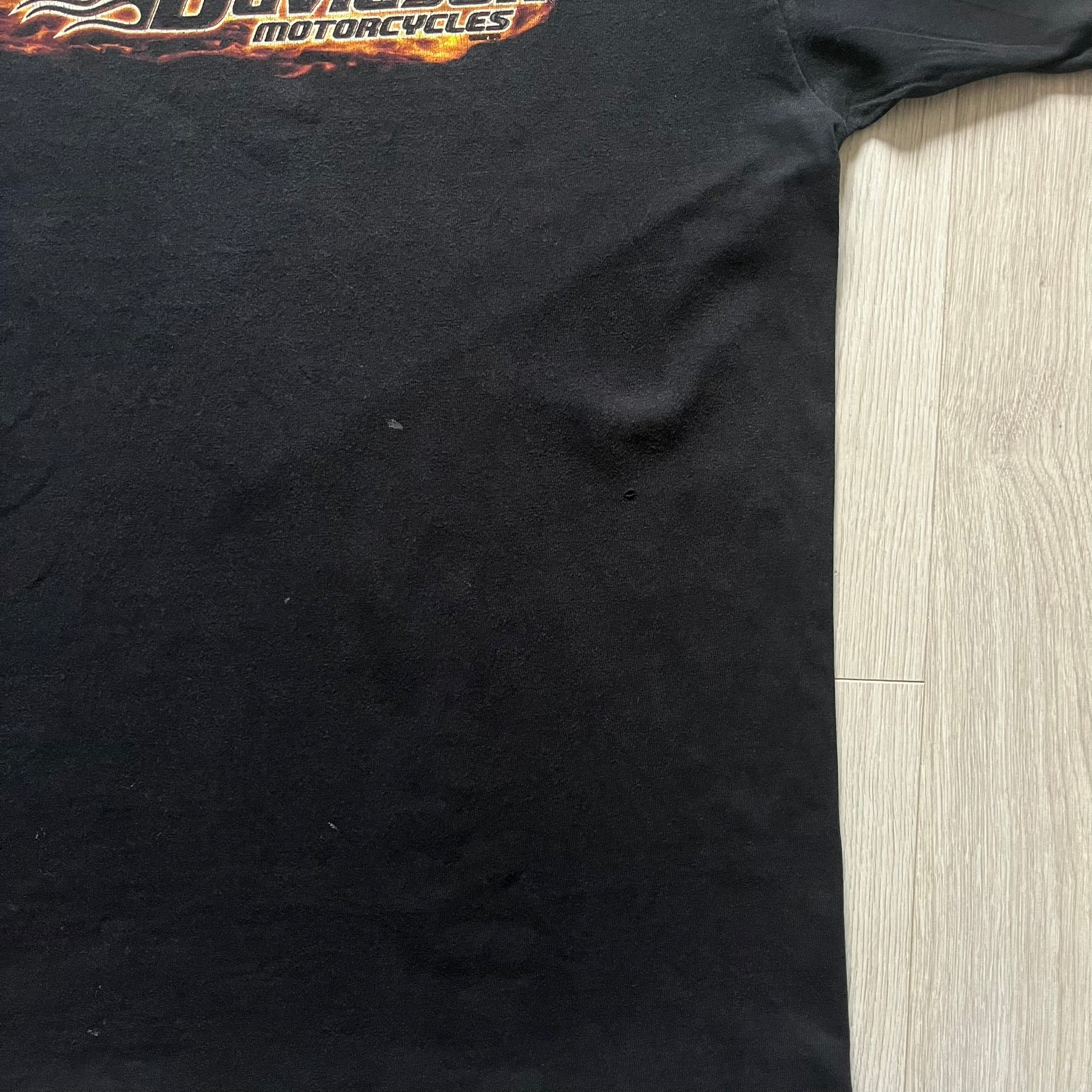  Harley Davidson Grand Island 2000’s Tee featuring a fiery Harley Davidson Motorcycles logo on the front and a USA flag graphic with Harley branding and “Grand Island, NE” text on the back. Classic black vintage tee with a timeless biker aesthetic.