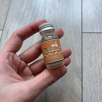 Small model Hermès Étrivière dog collar crafted from Natural Sable bridle leather. The collar features a stirrup-shaped buckle stamped HERMÈS, a metal D-ring for leash attachment, and leather stamped “HERMÈS PARIS MADE IN FRANCE.” It includes a 2 cm silver-plated stainless steel medal engraved “Hermès Sellier Paris,” with the reverse side suitable for engraving