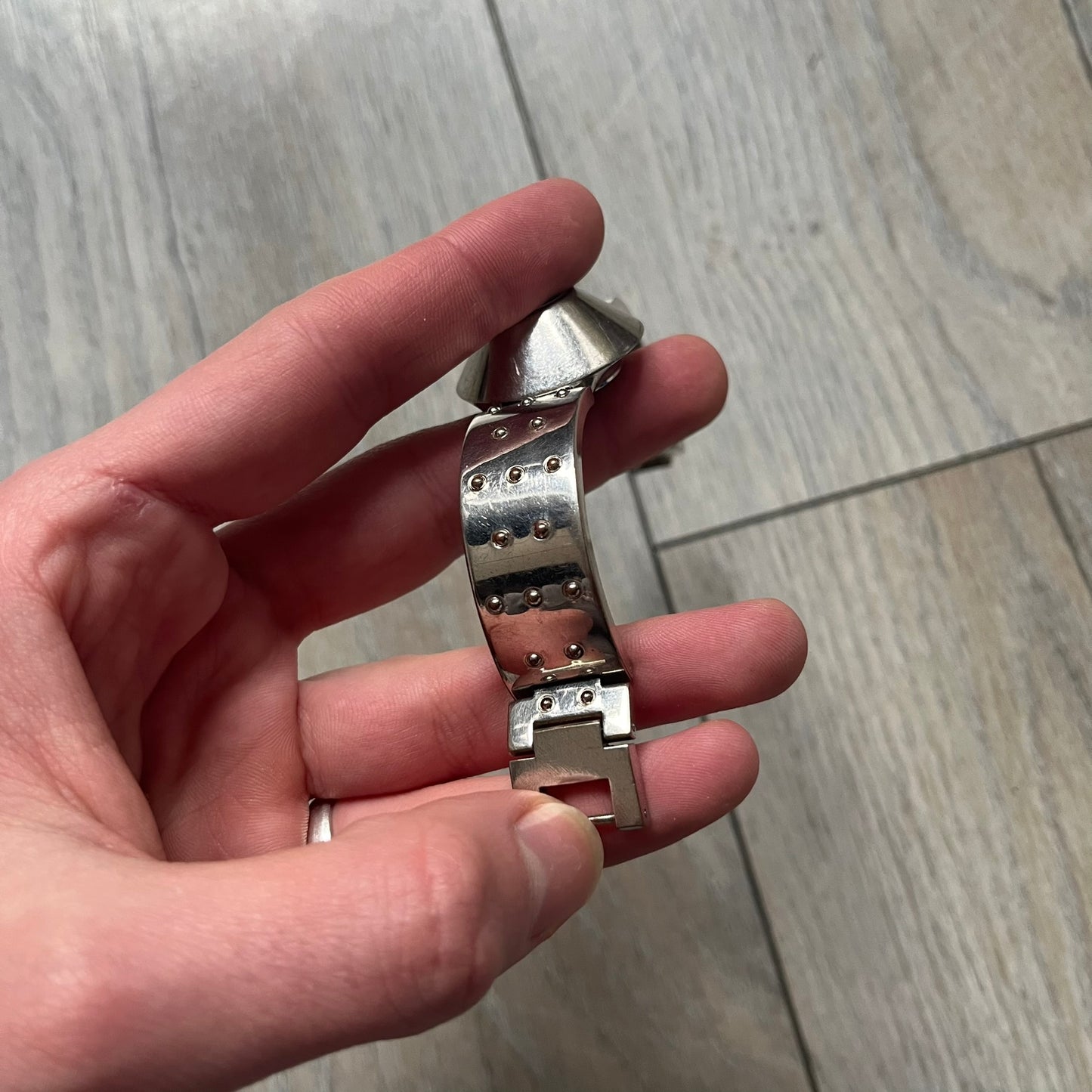 Hi-Tek Alexander “Cylinder” 90’s Analog Watch is a 1990s English-made timepiece featuring a black dial with a small Hi-Tek logo as the seconds hand. The cylindrical 3D case rises from the wrist, making the dial visible only from above, and the straps feature raised dot detailing. The stainless steel case back is branded with the Hi-Tek logo, designed specifically for smaller wrists.