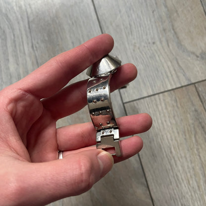 Hi-Tek Alexander “Cylinder” 90’s Analog Watch is a 1990s English-made timepiece featuring a black dial with a small Hi-Tek logo as the seconds hand. The cylindrical 3D case rises from the wrist, making the dial visible only from above, and the straps feature raised dot detailing. The stainless steel case back is branded with the Hi-Tek logo, designed specifically for smaller wrists.