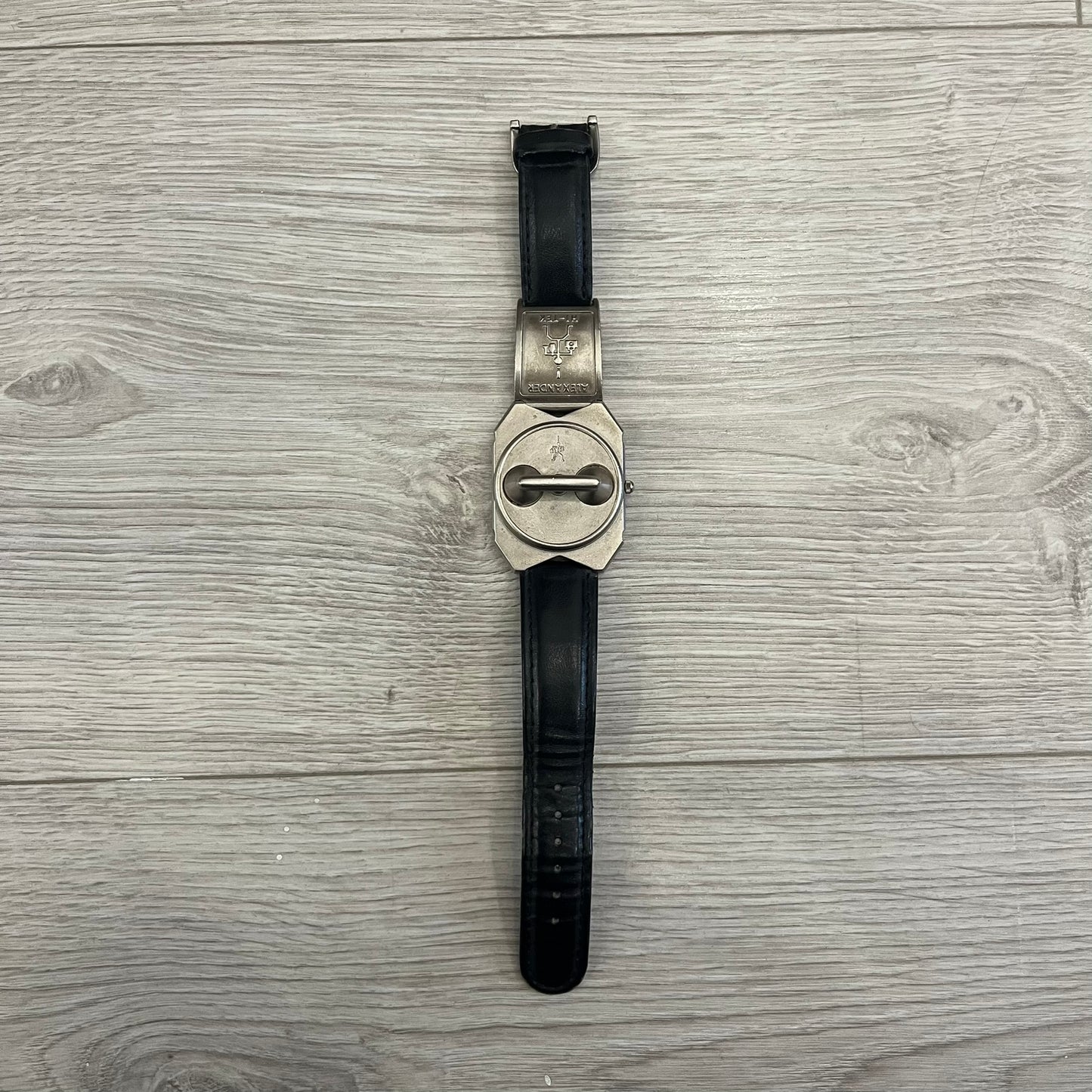 Hi-Tek Alexander “Jump Hour” 90's Analog Watch with a rare octagonal steel case and innovative rotation disc display. Hours appear in the left window and minutes in the right, revealed by the unique turnable cover. Made in England, this vintage 1990s watch features a chrome-plated stainless steel case, genuine leather strap, and an original design by Alexander Tasou of Hi-Tek Designs London. A true collector’s piece that is no longer in production.
