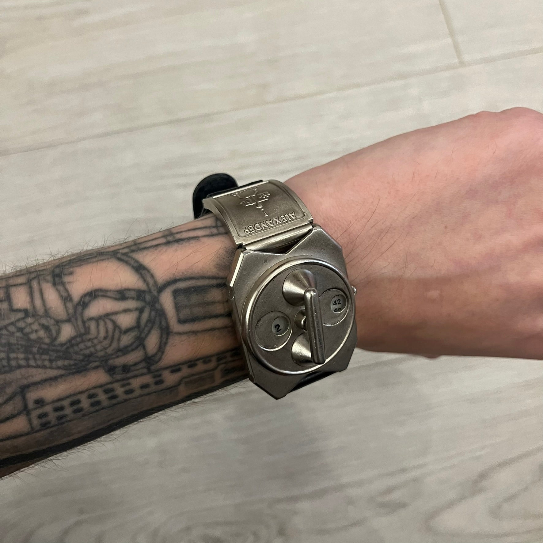 Hi-Tek Alexander “Jump Hour” 90's Analog Watch with a rare octagonal steel case and innovative rotation disc display. Hours appear in the left window and minutes in the right, revealed by the unique turnable cover. Made in England, this vintage 1990s watch features a chrome-plated stainless steel case, genuine leather strap, and an original design by Alexander Tasou of Hi-Tek Designs London. A true collector’s piece that is no longer in production.