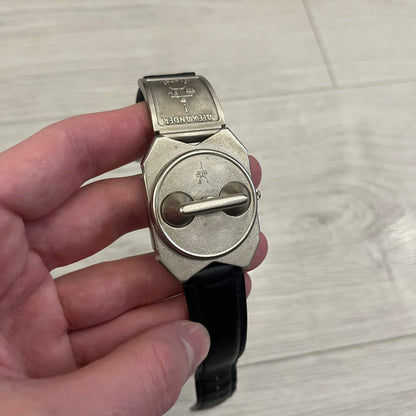 Hi-Tek Alexander “Jump Hour” 90's Analog Watch with a rare octagonal steel case and innovative rotation disc display. Hours appear in the left window and minutes in the right, revealed by the unique turnable cover. Made in England, this vintage 1990s watch features a chrome-plated stainless steel case, genuine leather strap, and an original design by Alexander Tasou of Hi-Tek Designs London. A true collector’s piece that is no longer in production.