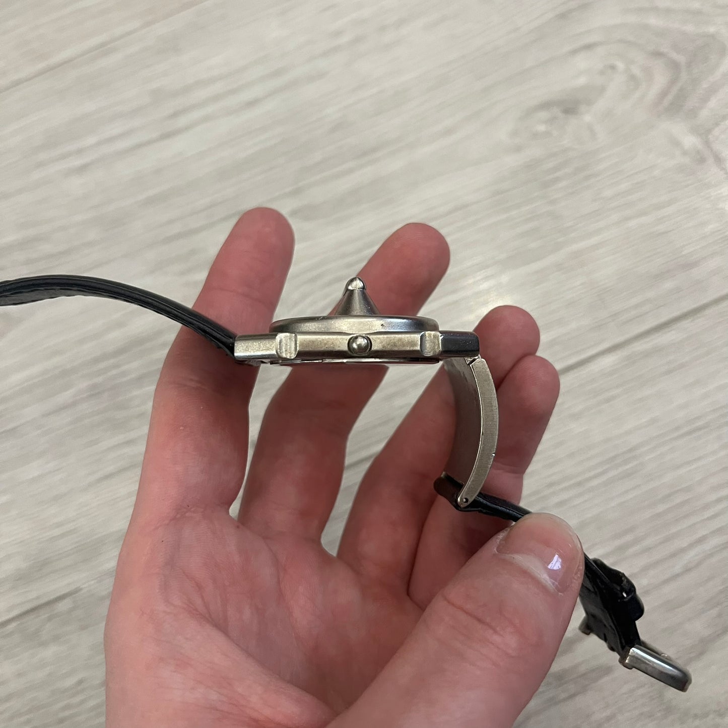 Hi-Tek Alexander “Jump Hour” 90's Analog Watch with a rare octagonal steel case and innovative rotation disc display. Hours appear in the left window and minutes in the right, revealed by the unique turnable cover. Made in England, this vintage 1990s watch features a chrome-plated stainless steel case, genuine leather strap, and an original design by Alexander Tasou of Hi-Tek Designs London. A true collector’s piece that is no longer in production.