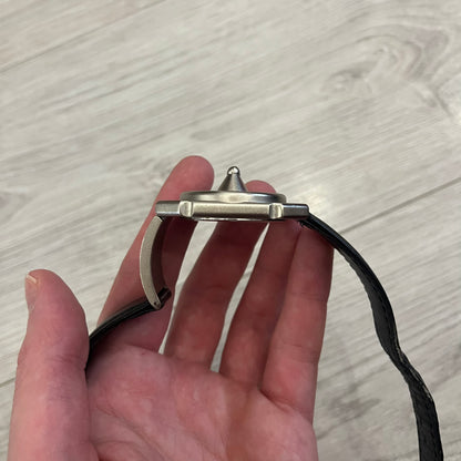 Hi-Tek Alexander “Jump Hour” 90's Analog Watch with a rare octagonal steel case and innovative rotation disc display. Hours appear in the left window and minutes in the right, revealed by the unique turnable cover. Made in England, this vintage 1990s watch features a chrome-plated stainless steel case, genuine leather strap, and an original design by Alexander Tasou of Hi-Tek Designs London. A true collector’s piece that is no longer in production.