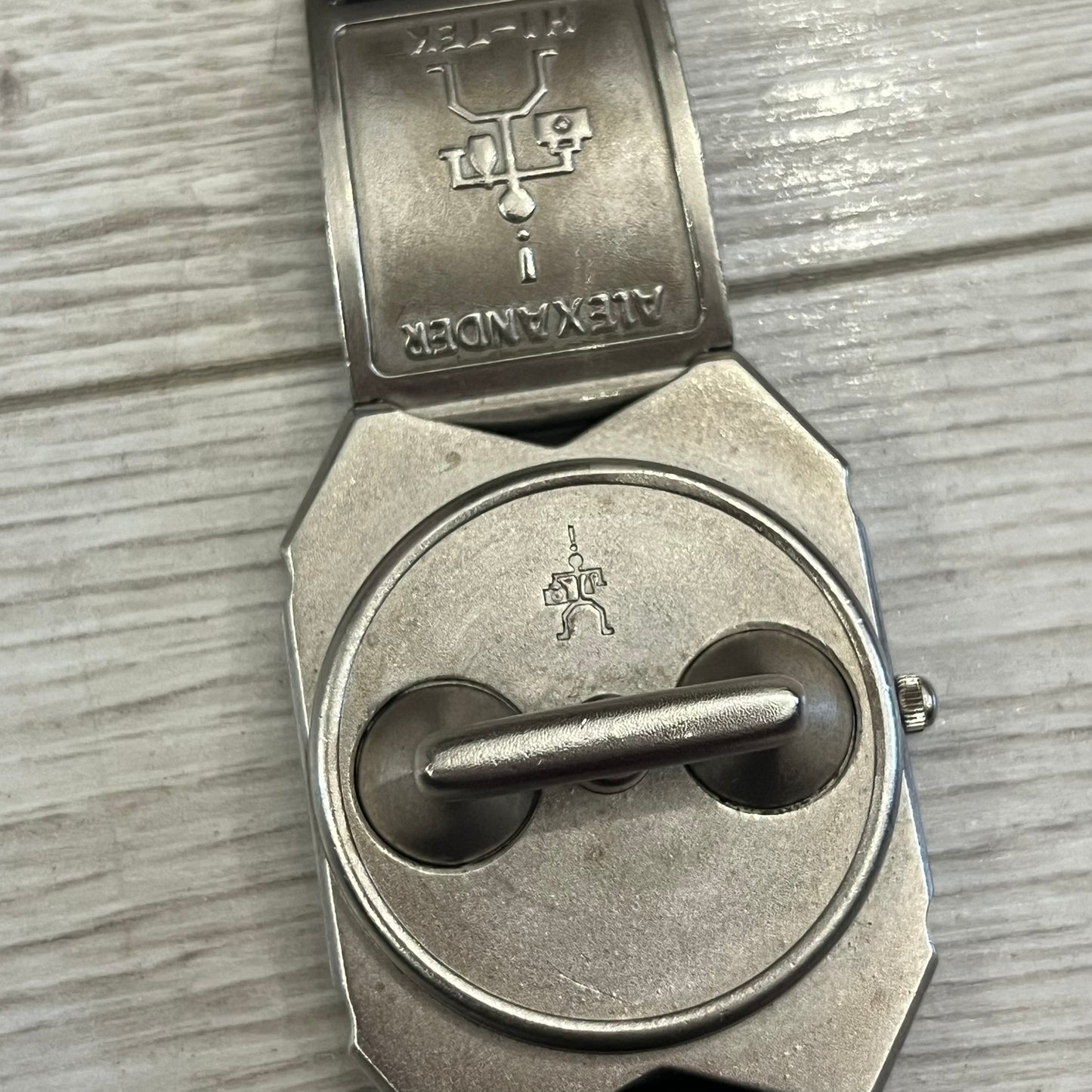 Hi-Tek Alexander “Jump Hour” 90's Analog Watch with a rare octagonal steel case and innovative rotation disc display. Hours appear in the left window and minutes in the right, revealed by the unique turnable cover. Made in England, this vintage 1990s watch features a chrome-plated stainless steel case, genuine leather strap, and an original design by Alexander Tasou of Hi-Tek Designs London. A true collector’s piece that is no longer in production.