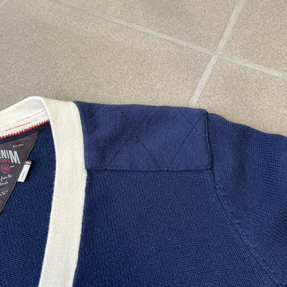 Hilfiger Denim 2012 Navy Varsity Cardigan is a navy cardigan with a white collar/hem trim and brown buttons, featuring two front pockets. It includes a large fuzzy "H" patch with text, two white straps on one sleeve, and a fuzzy white and navy "IV CHAMPS '85" patch.